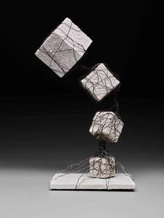 three white cubes on top of each other in the shape of an abstract sculpture