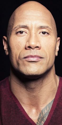 a bald man with tattoos on his arm