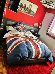 a bedroom with red carpet and an union jack comforter on top of the bed