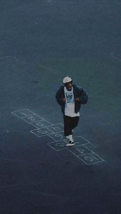 a man standing in the middle of an empty parking lot