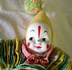 a clown mask sitting on top of a pile of cloths