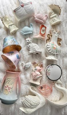there are many different ceramic items on the bed together and one is pink, blue, white