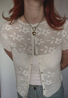 a woman with red hair wearing a white top