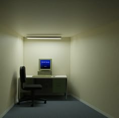 an empty room with a computer on the desk