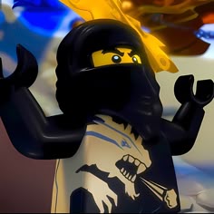a lego figure wearing a black mask and holding a yellow fire extinguisher
