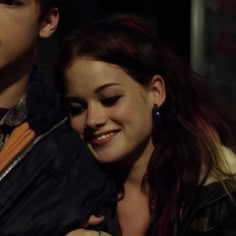 a young man and woman embracing each other