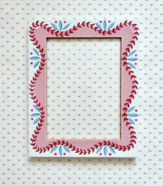 a pink and blue frame sitting on top of a wall next to a polka dot background