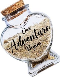 a glass jar filled with sand that says our adventure begins