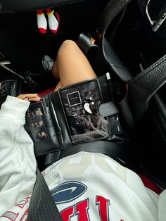 a woman laying in the back seat of a car with her cell phone on her lap