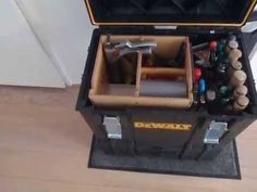 an open tool box filled with tools on top of a wooden floor