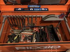 an orange toolbox filled with tools and wrenches