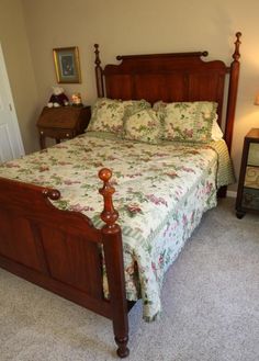 a bed sitting in a bedroom next to a night stand and lamp on top of a dresser