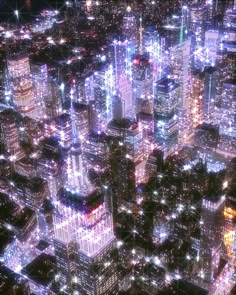 an aerial view of a city at night with lights and skyscrapers in the foreground