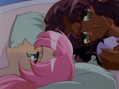 two women laying in bed with their heads together and one has her hand on the pillow