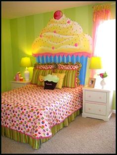 a bedroom decorated in bright colors with a large cupcake on the top of the bed