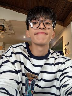 a young man wearing glasses sitting at a table