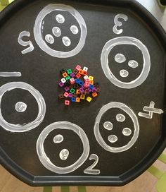 a child's black tray with numbers and dices on it