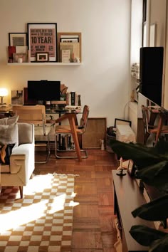 a living room filled with furniture and a flat screen tv mounted on a wall next to a window