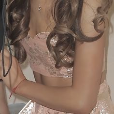 a woman in a pink dress is holding an umbrella and posing for the camera with long hair