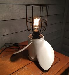 a light that is sitting on top of a wooden table next to a wire cage