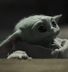 an adorable baby yoda doll laying on the floor