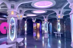 the inside of a building with multiple columns and lights on each side of the room