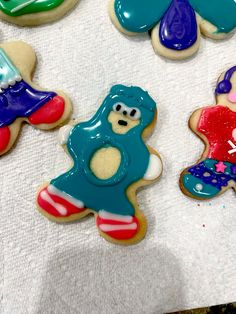 some decorated cookies are laying on a white towel and one is blue, the other is red