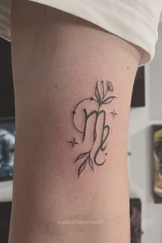 A close-up of a fine line Virgo zodiac tattoo with floral elements, celestial dots, and sparkles, blending astrology with nature-inspired details in a minimalist, elegant design.