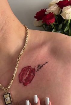 a close up of a person's chest with a tattoo on her left shoulder
