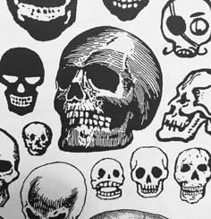 a bunch of skulls that are on top of a white sheet with black and white ink