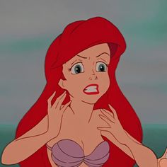 ariel from the little mermaid with her hands on her face and one hand up to her chest