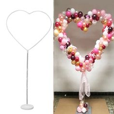 a heart shaped balloon on top of a table next to a stand with balloons in the shape of a heart