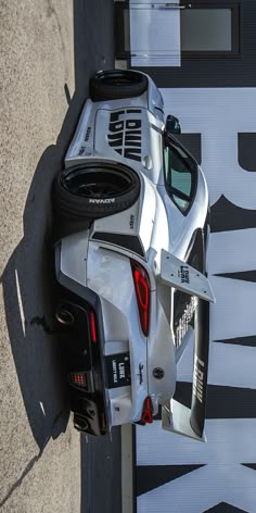 a car parked on the side of a road next to a wall