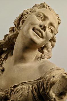 a close up of a statue of a woman's head and shoulders with hair blowing in the wind