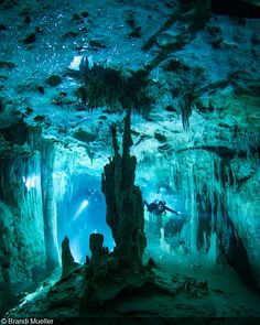 an underwater cave with people swimming in it