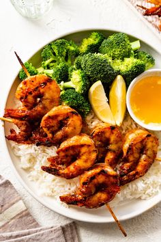 shrimp, broccoli and rice on a plate with dipping sauce