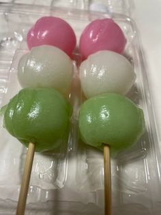 four lollipops with green, pink and white toppings