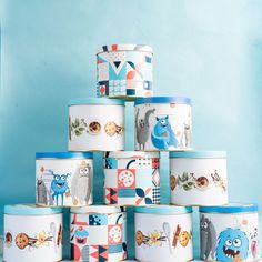 a stack of blue and white canisters sitting on top of each other in front of a blue wall