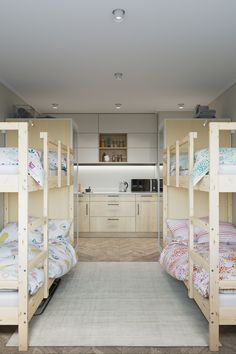 bunk beds are lined up in the middle of a room with beige walls and flooring
