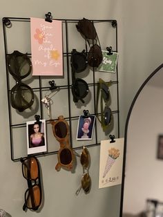 there are sunglasses hanging on the wall with pictures and photos attached to each one's sides