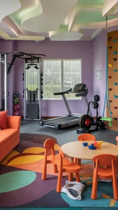 an exercise room with climbing wall and colorful rugs