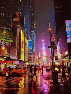 people crossing the street at night on a rainy day in times square, new york city