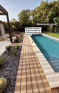 a wooden deck next to a pool surrounded by rocks and plants with the words outside dream above it