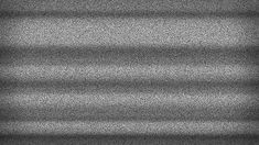 a black and white photo of the light coming in through blinds on a window sill