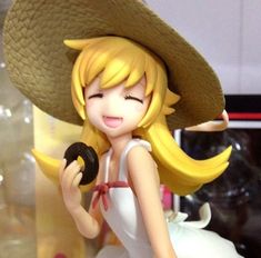 a figurine that is wearing a hat and holding a donut in her hand