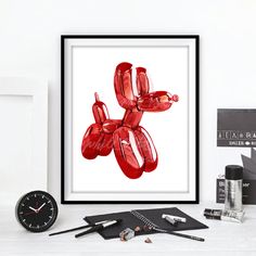 an art work is displayed on a white table with black and silver items around it