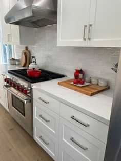 a kitchen with white cabinets and stainless steel appliances