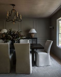 a dining room table with four chairs and a chandelier