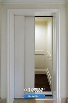 home elevator with 2-speed, automatic opening doors. This shows the white doors opening to reveal the white interior of the elevator with a recessed panel design.