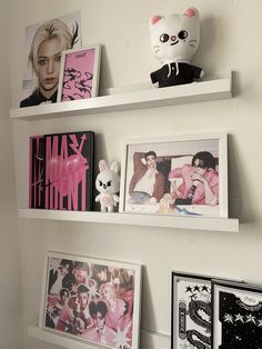 three white shelves with pictures and stuffed animals on them, one is above the other
